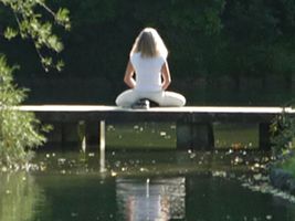 Gerlinde Schreiner meditiert auf einer kleinen Brücke im Englischen Garten